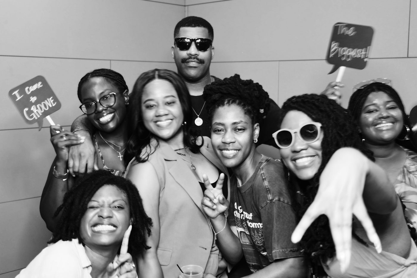 Group of friends with props at a black and white photo booth